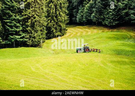 Alte Schlepper auf einem Feld in den bayerischen Alpen Stockfoto