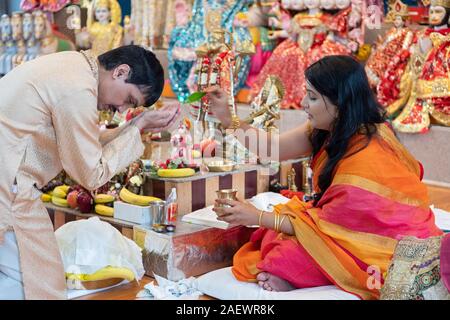 Eine schöne Hindu Priesterin führt morgen Dienstleistungen an einem Tempel in Jamaica, Queens, New York City. Stockfoto