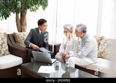 Gerne älteres Paar im Gespräch mit Finanzberater im Wohnzimmer Stockfoto