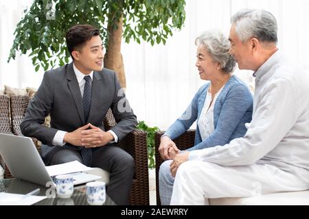 Gerne älteres Paar im Gespräch mit Finanzberater im Wohnzimmer Stockfoto