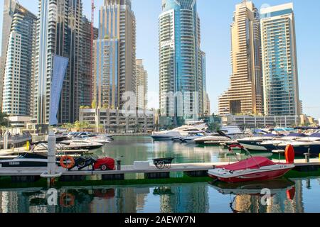 Dubai/VAE - November 11, 2019: Dubai Marina District mit schönen Wolkenkratzer und Yachten. Dubai Marina Yachten Parkplatz mit hölzernen Pier. Stockfoto