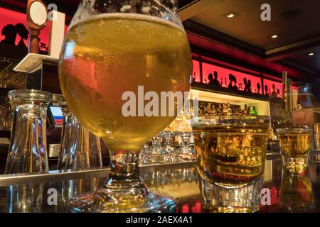 Chicago IL, Circa 2019: Whiskey und Bier sitzen auf einem Balken oben in einem ausgefallenen Restaurant wie der Barkeeper Getränke bereitet sich für Auftraggeber und Kunden auf Stockfoto