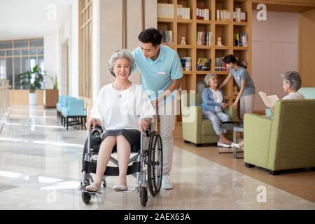 Junge Krankenschwester Assistent kümmert sich um ältere Leute Stockfoto