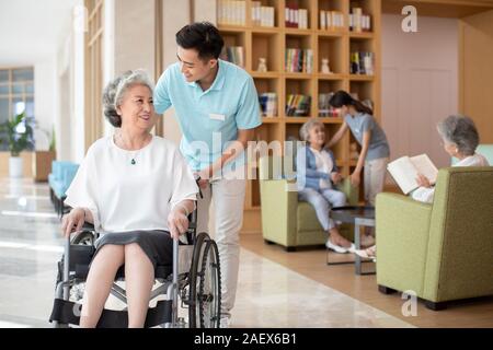 Junge Krankenschwester Assistent kümmert sich um ältere Leute Stockfoto