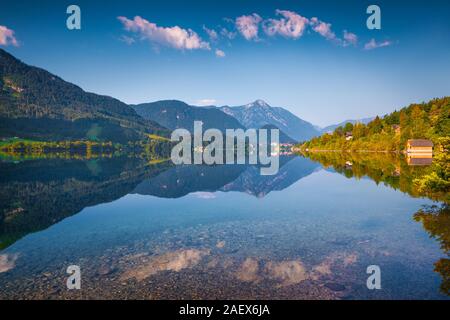 Deep Blue Sky im Spiegel der Wasser Oberfläche auf dem Grundlsee nieder. Archkogl Dorf im Morgennebel. Alpen, Österreich, Europa. Stockfoto