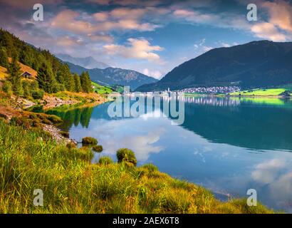 Sonnigen Sommer Szene auf Reschen See. Reschen Dorf im Morgennebel. Alpen, Europa. Region Bozen, Südtirol, Italien, Europa. Stockfoto