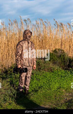 Naturforscher Fotograf in Aktion, mit Camouflage und Kamera, in der Wüste. Stockfoto