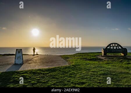 Auf Hengistbury Head Anzeigebereich mit Marker Stein und großer Stuhl log mit Sonne, mit Blick auf das Meer Stockfoto