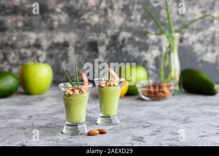 Avocado- und grüner Apfel Mousse mit Garnelen und Mandeln. Teil Vorspeise für ein Buffet oder Bankett in ein Glas. Stockfoto