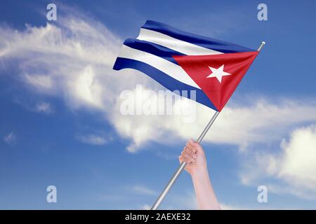 Weibliche hand winkt kubanische Flagge gegen den blauen Himmel mit Wolken. Realistische Spiegelungen und Texturen mit hoher Auflösung. 3D-Rendering. Stockfoto