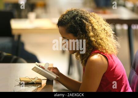 Kopf geschossen von lächelnden African American tausendjährigen Weiblich mit Gerät, Technologie lifestyle Stockfoto