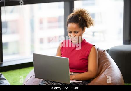 Kopf geschossen von lächelnden African American tausendjährigen Weiblich mit Gerät, Technologie lifestyle Stockfoto