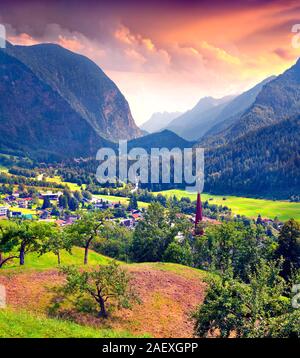 Blick aus der Vogelperspektive von Oetz Dorf und Heiliger Georg Kirche in bunten Sommer Sonnenaufgang. Österreich, Alpen, Europa. Stockfoto