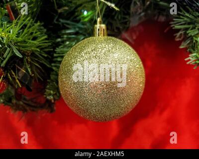 Gold glänzend isoliert christmas ball Dekoration auf rotem Hintergrund, Konzept Stockfoto