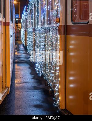 Festlich licht Straßenbahn (fenyvillamos) bei Nacht eingerichtet. Weihnachtszeit in Budapest. Vintage Tram vom Stadtzentrum Budapest mit Weihnachtsbeleuchtung dekoriert Stockfoto