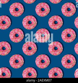 Helle essen Nahtlose isometrische Muster mit Donuts. Rosa glasierten Krapfen mit bunten Zucker Streusel auf Classic blau Farbe Hintergrund. Minimal abstrakt Stockfoto