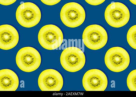 Kreative nahtlose Muster von Neon Gelb kiwi Slice mit Samen auf Classic blau Farbe Hintergrund. fotografie Collage. Konzept Kunst Minimal essen Konzept Stockfoto