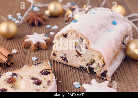 Traditionelle deutsche Weihnachtskuchen Stollen mit Cookies und Dekoration auf hölzernen Tisch Stockfoto