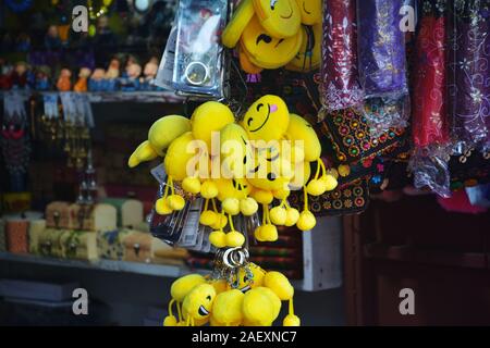 Nahaufnahme von Gelbe weiche runde Polster gefüllte emoji Anhänger hängen in Trauben in einem Geschäft in der Elefant fällt von Shillong. Stockfoto