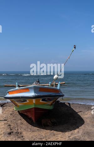 Angeln Boot steht auf dem Ocean Beach. Der Eisvogel Vogel sitzt auf einem hausgemachten Angeln Leuchtturm auf Fischerboot. Stockfoto