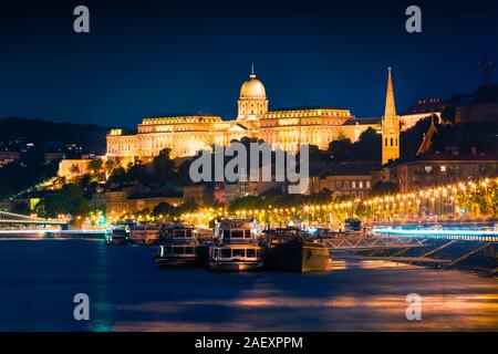 Am Abend Blick auf die Budaer Burg mit Lichter und das Schiff auf der Donau. Farbenfrohe Stadtbild in Budapest, Ungarn, Europa. Künstlerischen Stil post Prozesssignalen Stockfoto