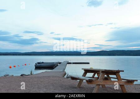 Picknicktisch und Holz- Dock auf dem See in Schweden. Stockfoto