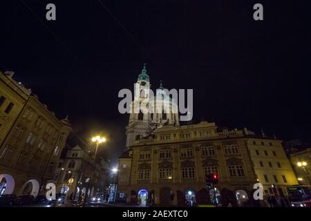 Prag, Tschechien - NOVEMBER 3, 2019: Malostranaske Namesti Square bei Nacht mit der Koste Svety Mikulase Kirche (St. Nikolaus) beleuchtet. Es ist die Stockfoto