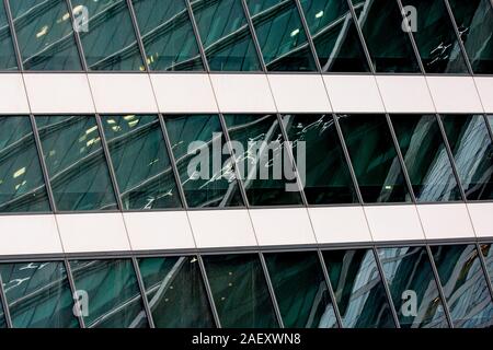 Fragment der modernes Gebäude. Close-up. Eine schöne Kombination aus Metall und Glas. Effektive Brechung der Strukturen in der glänzenden Oberflächen. Stockfoto