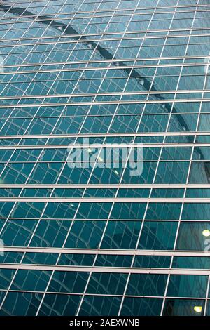 Fragment der modernes Gebäude. Close-up. Eine schöne Kombination aus Metall und Glas. Effektive Brechung der Strukturen in der glänzenden Oberflächen. Stockfoto