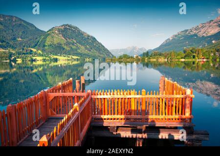 Helle, sonnige Aussicht auf kleinen Boot Pier in Gessl Dorf. Farbenfrohe Sommer morgen auf der Grundlsee, Liezen Bezirk der Steiermark, Österreich, Alpen. Europa Stockfoto