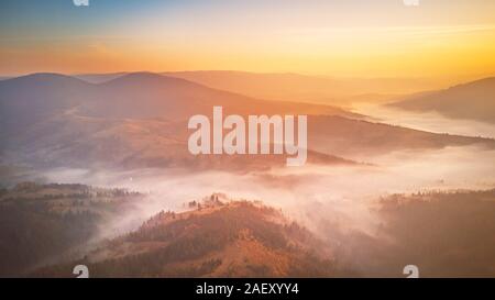 Antenne Panorama der wunderschönen Herbst Berge. Sonnenaufgang über Berg nebligen Tal. Misty woodland am Morgen. Karpaten, Ukraine Stockfoto