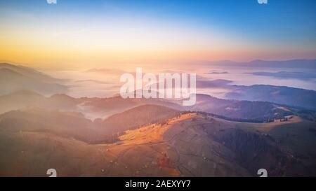 Antenne Panorama der wunderschönen Herbst Berge. Sonnenaufgang über Berg nebligen Tal. Misty woodland am Morgen. Karpaten, Ukraine Stockfoto