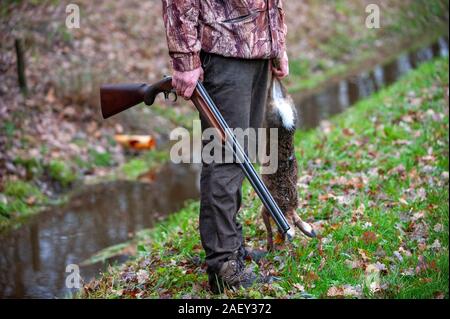 Ein Jäger mit einem toten Hasen, die gerade von ihm geschossen wurde. Stockfoto