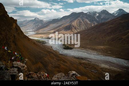 Die spiti Fluss schlängelt sich durch die Spiti Valley von den Gipfeln des Himalaya und Buddhistische Gebetsfahnen in der Nähe von Kaza, Himachal Pradesh, Indien flankiert. Stockfoto