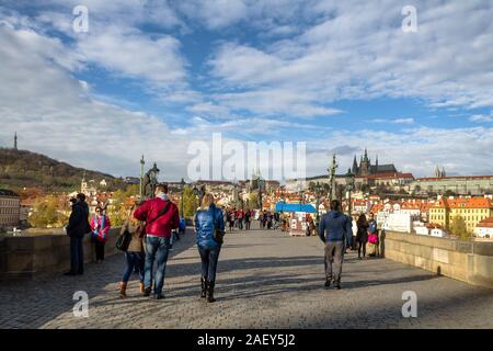 Touristen zu Fuß auf der Karlsbrücke auf einen Herbst morgen mit der Prager Burg im Hintergrund Stockfoto
