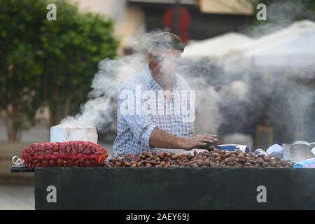 Senior Vendor verkaufen gerösteten Kastanien auf der Straße in Santa Cruz, Provinz Sevilla, Sevilla, Spanien Stockfoto