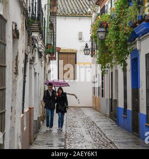 Paar wandern entlang der Altstadt gasse in Regen, Distrito Centro, Crdoba Crdoba, Provinz, Spanien Stockfoto