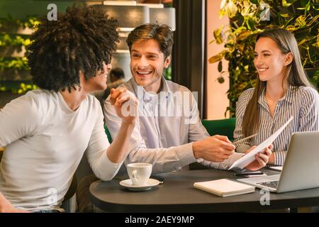 Produktives Arbeiten. Happy Business Team diskutieren profitable Jahresbericht im Cafe Stockfoto