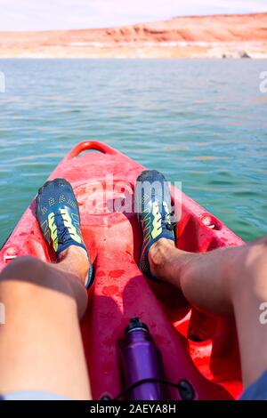 Kajak in Lake Powell zu Antelope Canyon mit Beinen Füße Wasser Schuhe an der Vorderseite des roten Kajak Boot und blaues Wasser Stockfoto