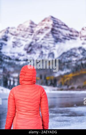 Maroon Bells sunrise mit der Frau an Spitze in Aspen, Colorado Rocky Mountain und Herbst gelb Laub und Schnee im Winter zugefrorenen See Stockfoto