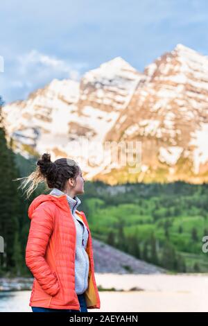 Kastanienbraune Glocken in Aspen, Colorado im Jahr 2019 Sommer bei Sonnenaufgang mit jungen Mädchen Frau im Mantel mit Gipfelblick Am See 1. Stockfoto