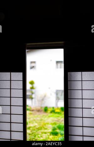 Traditionelle japanische Home Haus oder Ryokan Hotel in Japan mit Nahaufnahme des offenen shoji Schiebetüren Papier Türen zu Green Garden Stockfoto