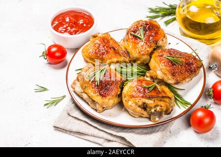 Gebackene Hühnerkeule mit Kräutern auf weiße Platte. Stockfoto