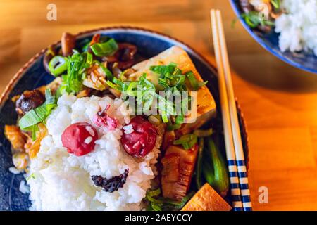 Traditionelle japanische Platte flach Draufsicht auf Holztisch und Gemüse mit Reis shiso, umeboshi, Essstäbchen und Bambussprossen mit grünen o Stockfoto
