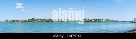 Naples, Florida Nelson's Walk Häuser Gebäude mit Wasser auf Dollar bay Palmen, blauer Himmel in der Wohngemeinschaft Ferienwohnungen Panorama Stockfoto