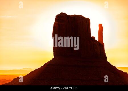 Ansicht Nahaufnahme von einem berühmten Mesa butte Fäustling Formationen mit rot orange Rock Farbe am Horizont im Monument Valley Canyons bei Sonnenaufgang im Arizona Stockfoto