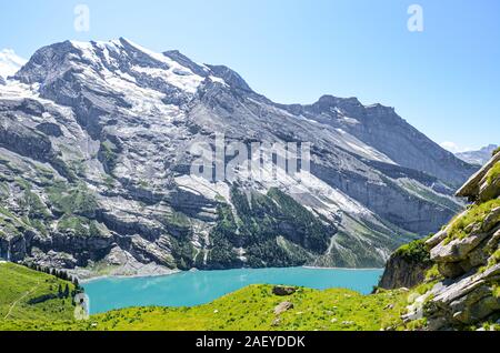 Schöne Oeschinensee See in der Nähe von Kandersteg in der Schweiz. Türkisfarbenen See von steilen schneebedeckten Bergen umgeben. Beliebte Touristenattraktion in den Schweizer Alpen. Sommer Alpine Landschaft. Stockfoto