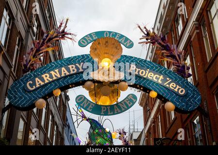 London, UK, 1. Dezember 2019: Eingang zum berühmten Carnaby Street in Soho. Die weihnachtsdekorationen werden recycelt und wiederverwendet Dam zu markieren. Stockfoto