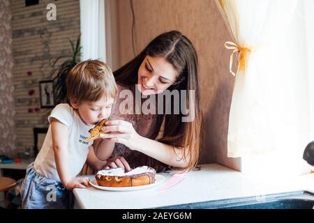 Mutter und Sohn essen Kuchen in der Küche Stockfoto