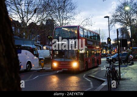 London, Großbritannien. 11 Dez, 2019. Dezember twilight mit Bussen auf Chiswick High Road. Busse E3, H 91, 267 und 391 machen sich auf den Weg durch die Dämmerung. Credit: Peter Hogan/Alamy leben Nachrichten Stockfoto